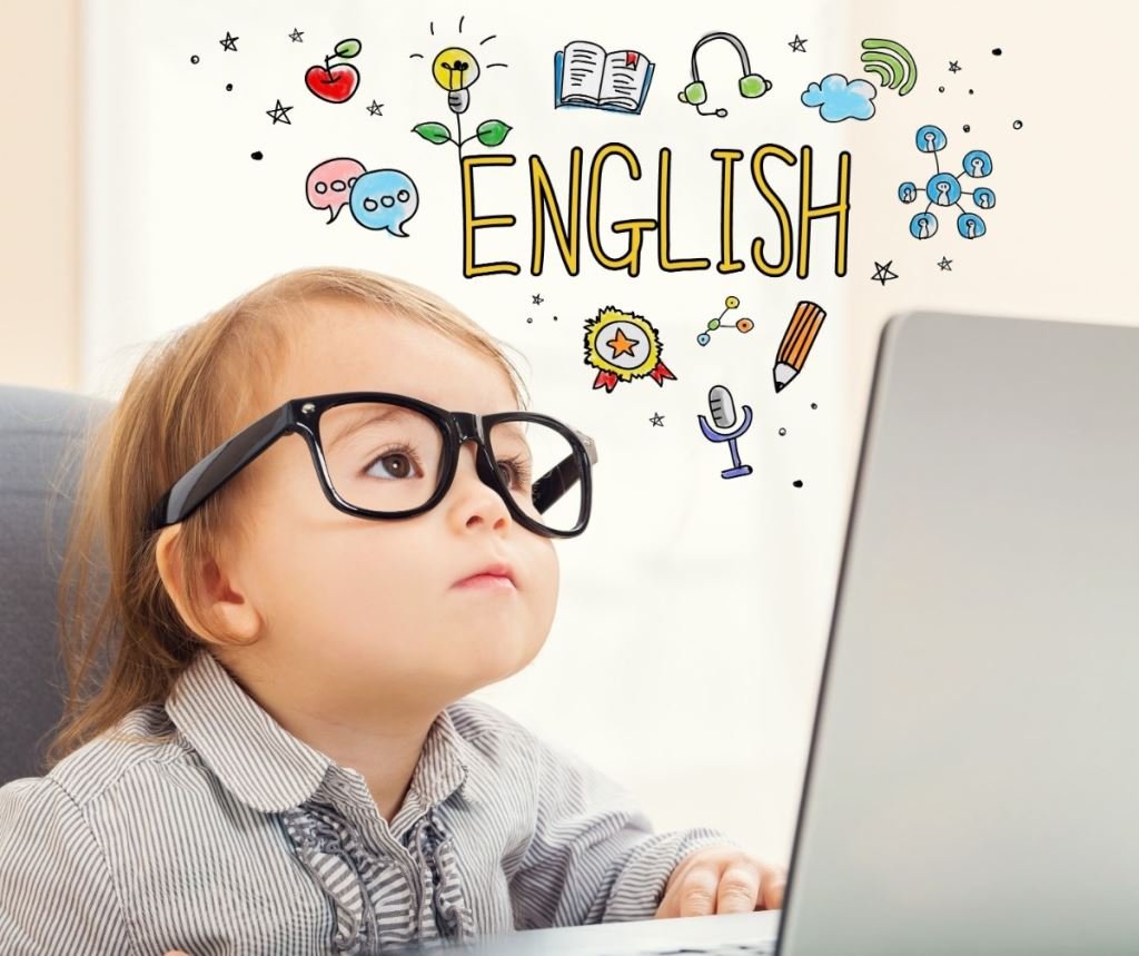 戴著眼鏡的幼兒看著筆記型電腦，思考著英語學習。 上面顯示“ENGLISH”。