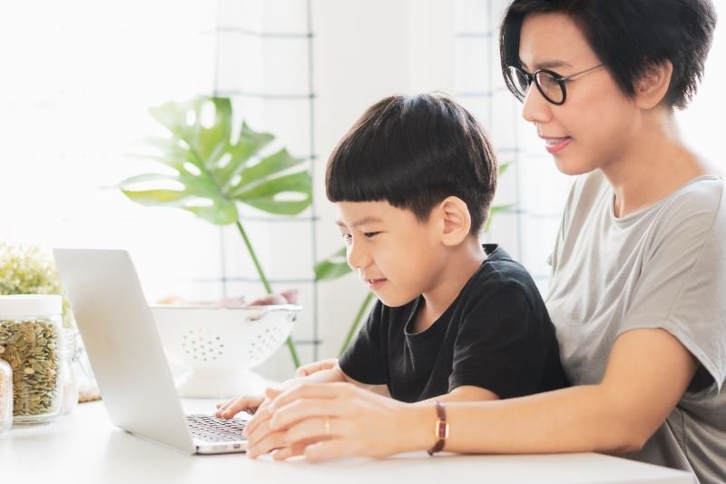母子倆在家使用筆記型電腦一起學習英語。