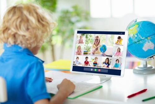 孩子透過平板電腦與多位老師和學生一起參加線上英語課程。
