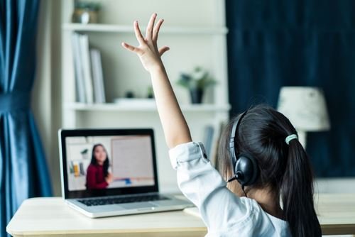 女孩參加線上英語課,舉手回答問題。