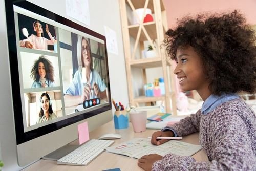 女孩在電腦螢幕上參加由多位老師授課的線上英語課。