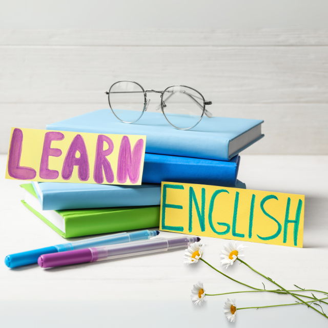 一堆寫著「學習英語」和「學習」的書、眼鏡和花。