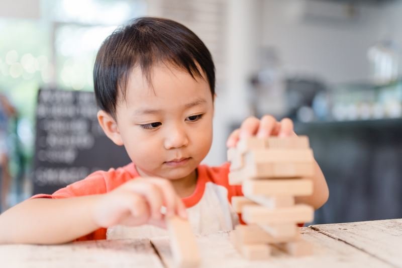 幼兒全神貫注地玩積木。
