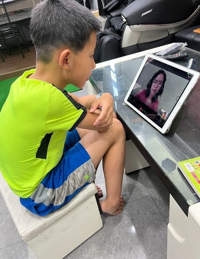 男孩與老師進行視訊會議，線上學習