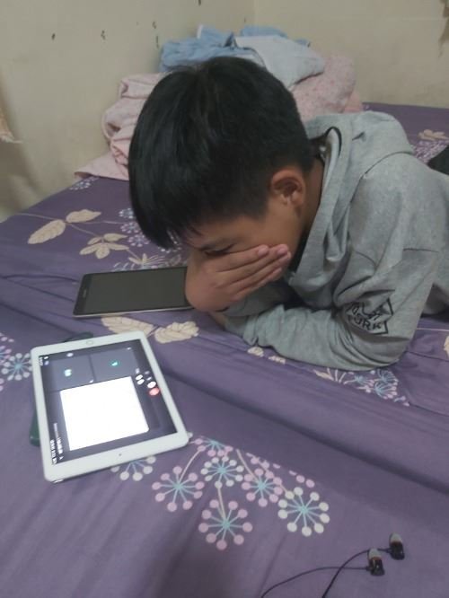 心煩意亂的男孩使用平板電腦上網課。 學生回饋。