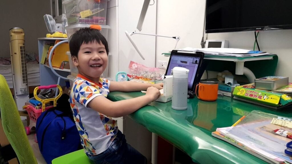 快樂的小男孩在書桌前進行線上學習。 TK 學生回饋。