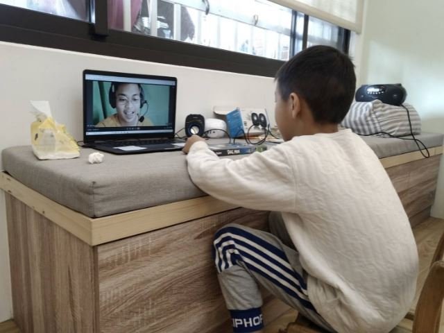 男孩與老師進行視訊會議,在家線上學習。