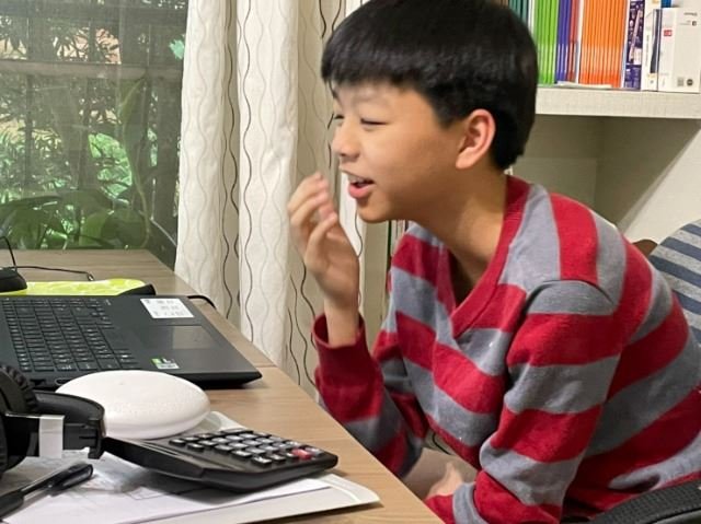 男孩在參加線上課程時微笑。 早上的課堂回饋。