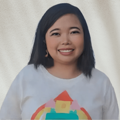 身穿彩虹圖案白襯衫的艾賽爾老師面帶微笑。